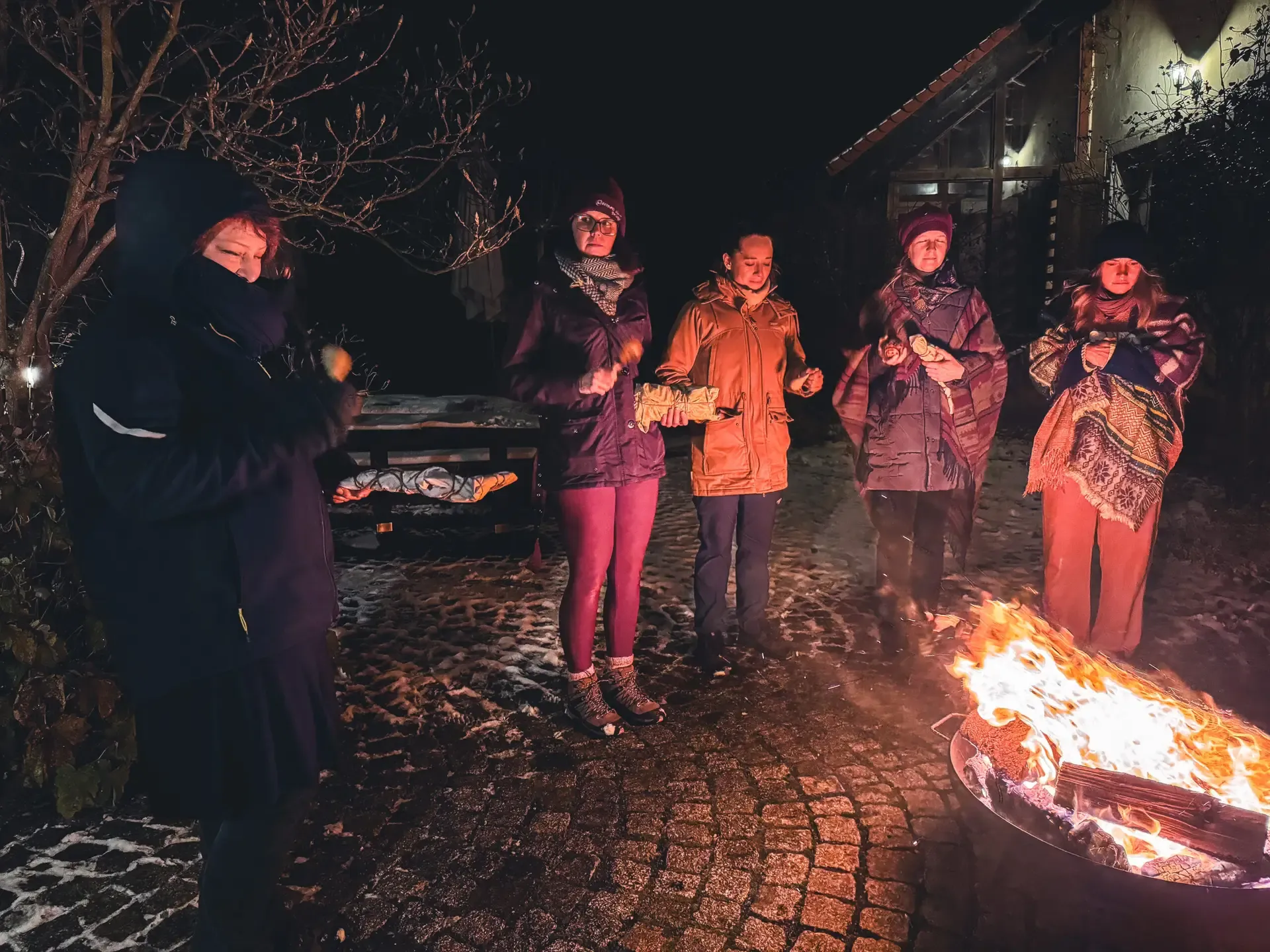 Kreis um das Feuer im Hof bei Nacht